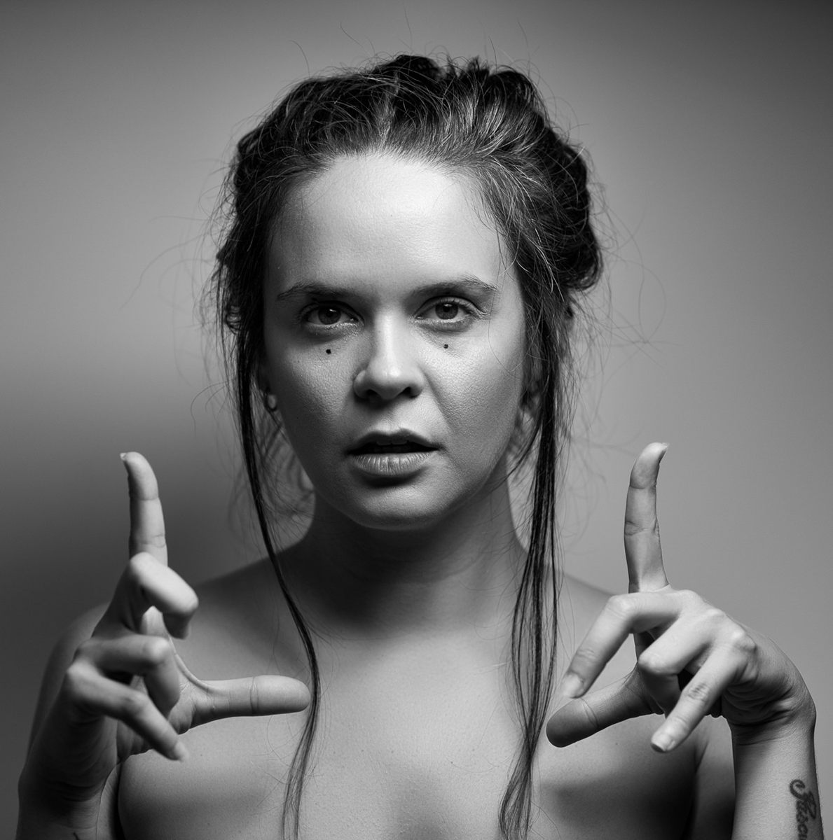 Retrato en blanco y negro de Teresita Aljibes, con las manos en gesto de encuadre.